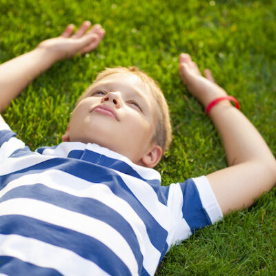 Boy laying down on the grass.