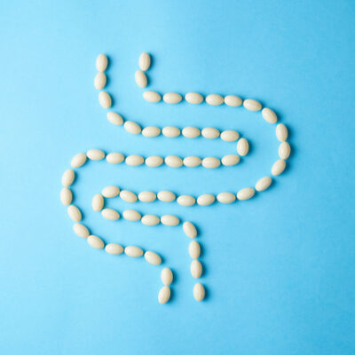 Probiotic and supplement pills forming a human intestine.