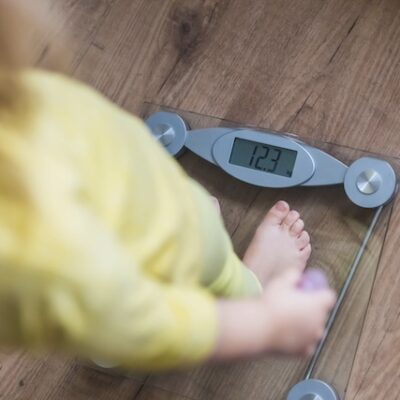 Child being weighed on a scale.
