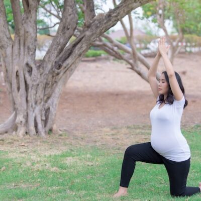 Pregnant woman exercising in a park.