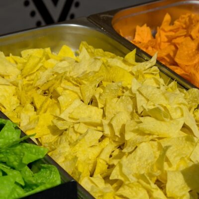 Multi colored tortilla chips in trays.