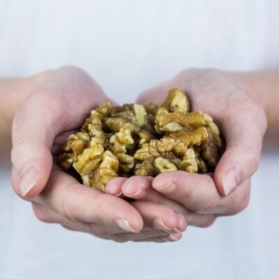 Woman showing handful of walnuts in close up.