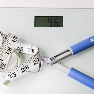 Diabetes medication pen, measurement tape, and a scale.