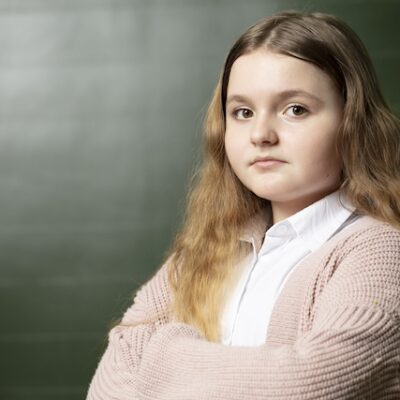 Portrait of a schoolgirl in front of a blackboard.