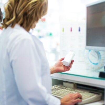 Pharmacist holding up a bottle of medicine.